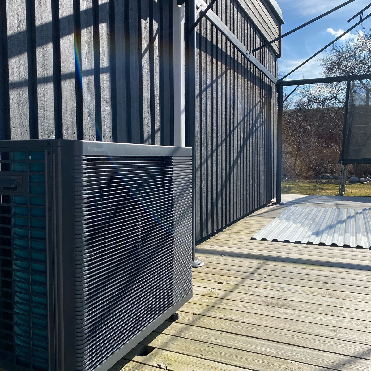Panasonic Aquarea K-Gen luft-vattenvärmepump mot svart fasad